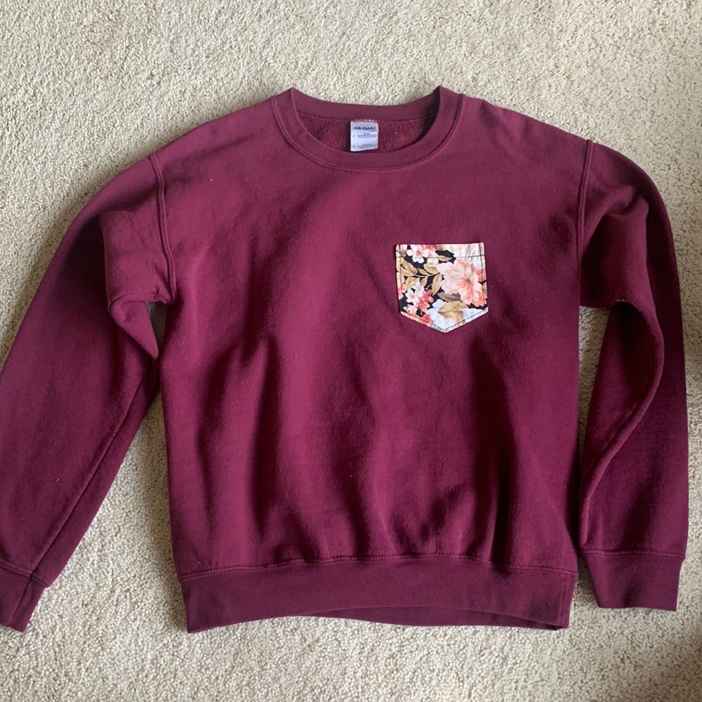 Maroon crewneck sweatshirt with floral pocket on front